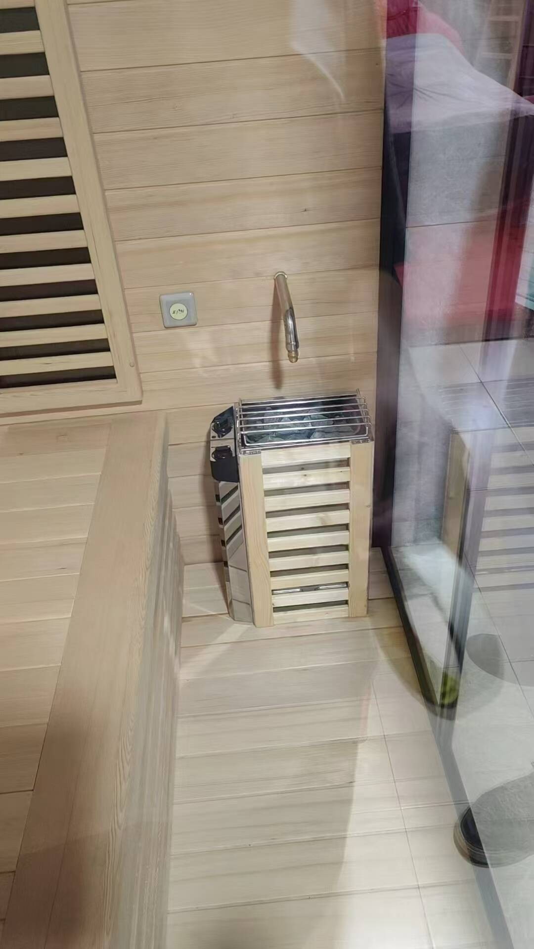 A sauna cabin with its heater and bench installed.