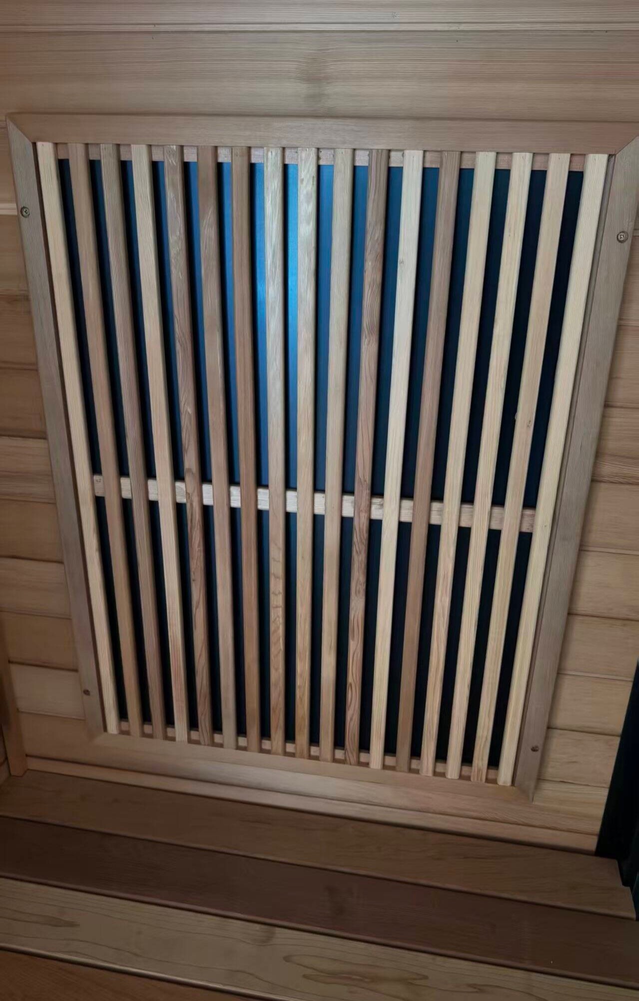 A sauna room unit standing on the workshop floor.