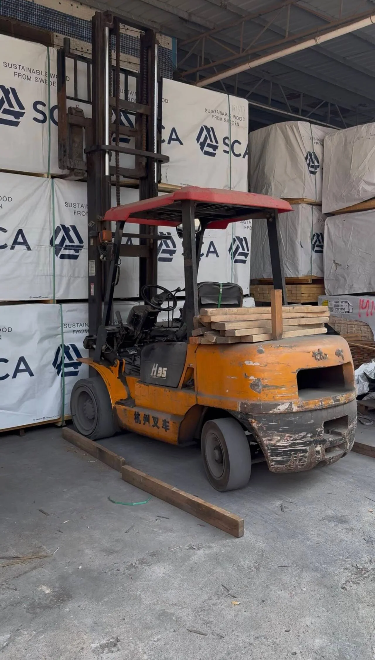 A forklift moving wrapped timber between the store and the shop